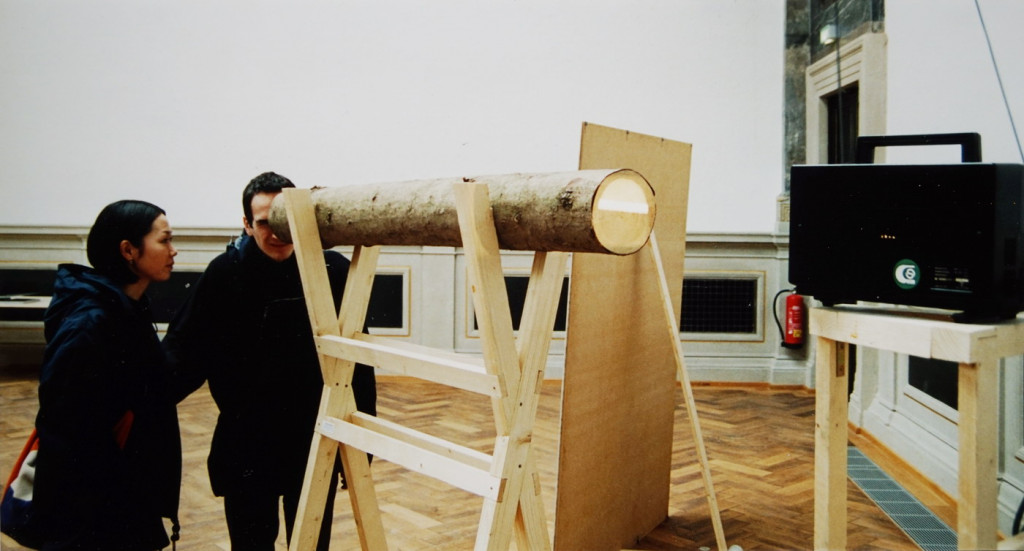 mit Rücksicht auf Friedrich, 2002, Rundholz (Fichte), 132 x ø 16 cm mit Super 8-Film-Projektion | mit Rücksicht auf Friedrich, 2002, trunk piece (spruce), 132 x ø 16 cm and Super 8-film projection
